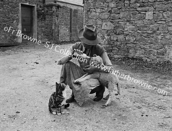 MAN BOTTLE FEEDING LAMB